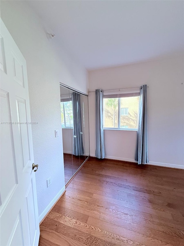 spare room with hardwood / wood-style floors and plenty of natural light