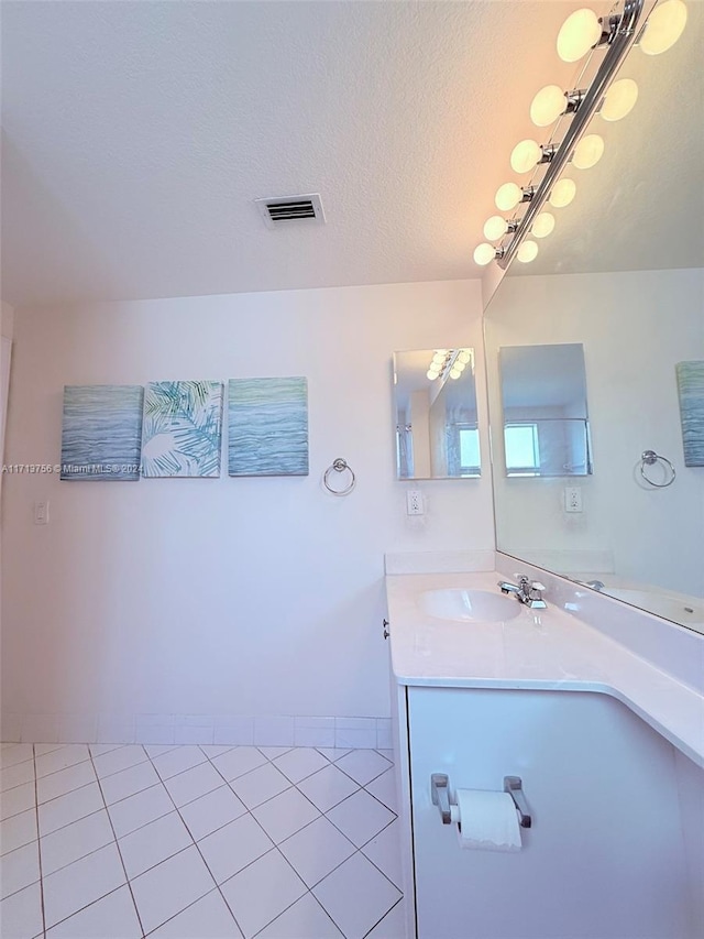 bathroom with vanity, a textured ceiling, and tile patterned floors