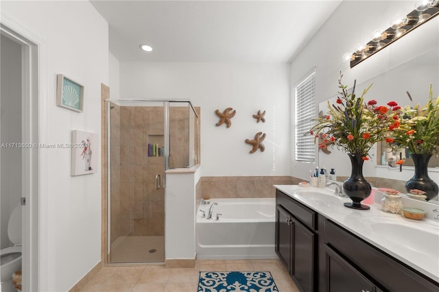 bathroom with tile patterned floors, vanity, and shower with separate bathtub