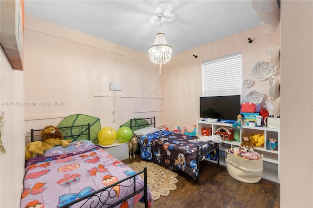 bedroom with hardwood / wood-style floors and a notable chandelier