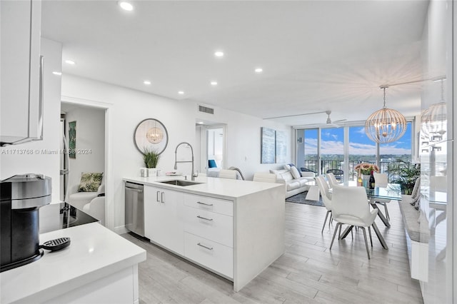 kitchen with dishwasher, pendant lighting, white cabinetry, and sink