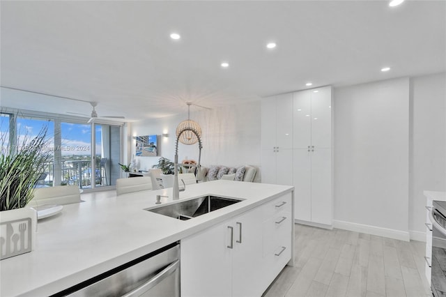 kitchen with white cabinetry, dishwasher, ceiling fan, sink, and pendant lighting