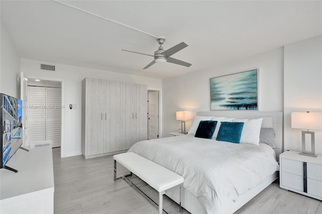 bedroom featuring ceiling fan, a closet, and light wood-type flooring