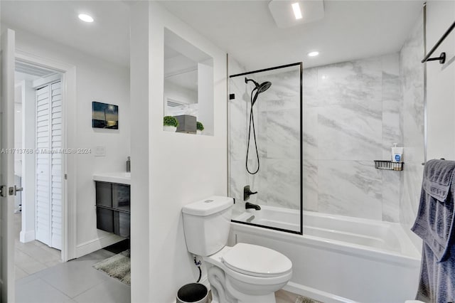 full bathroom with tile patterned floors, vanity, tiled shower / bath combo, and toilet