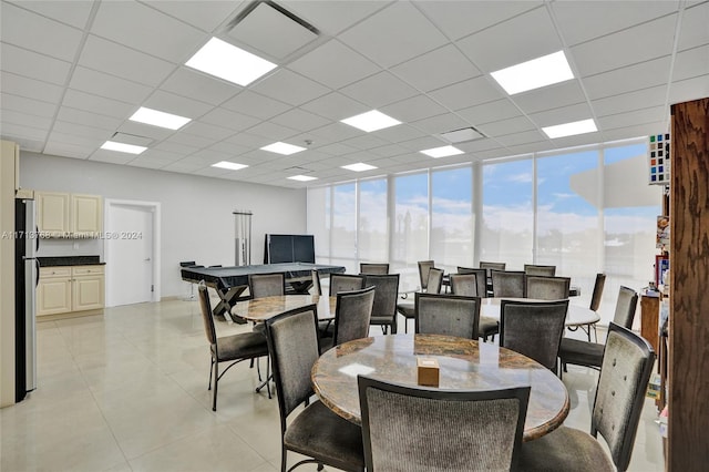 dining area with a paneled ceiling and expansive windows