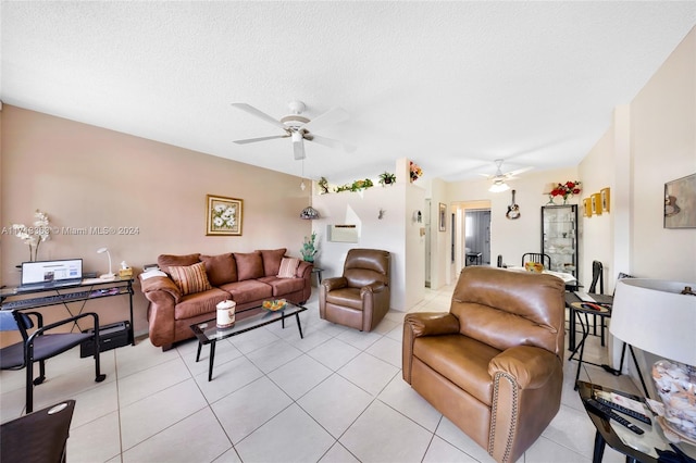 living room featuring ceiling fan, light tile patterned flooring, and a textured ceiling