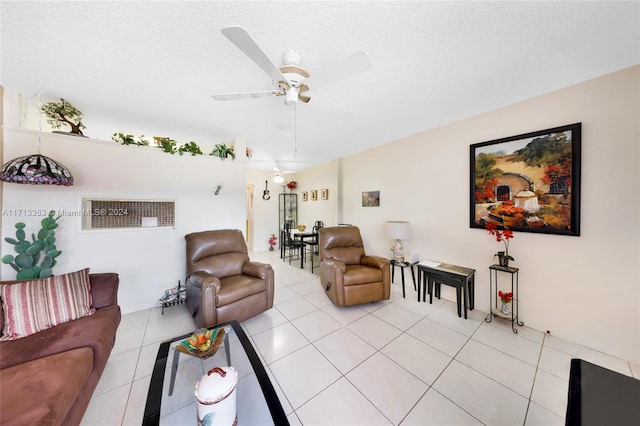 living room featuring ceiling fan, light tile patterned flooring, and a textured ceiling