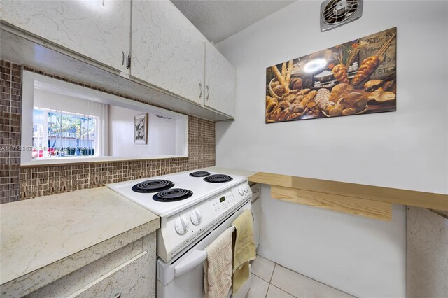 kitchen with decorative backsplash, light tile patterned flooring, white electric range oven, and a textured ceiling