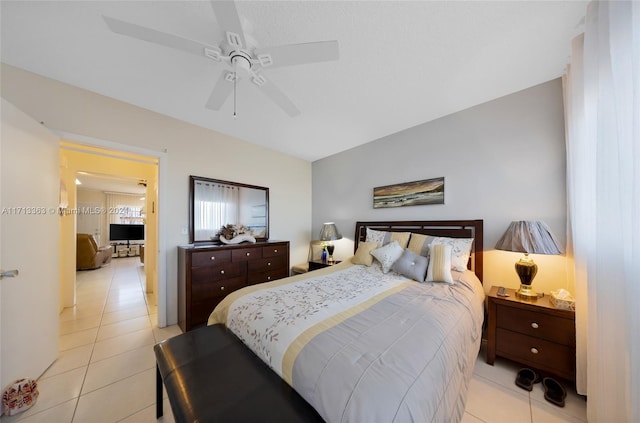 tiled bedroom with ceiling fan and lofted ceiling