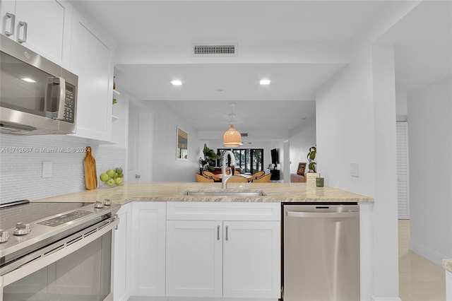 kitchen with kitchen peninsula, appliances with stainless steel finishes, white cabinetry, and sink