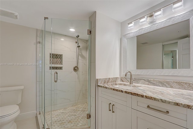 bathroom with tile patterned flooring, a shower with door, vanity, and toilet