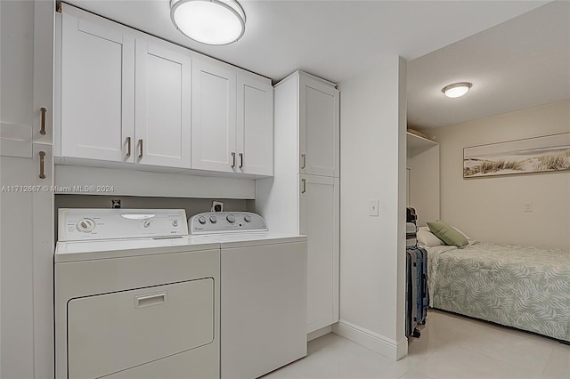 laundry area featuring separate washer and dryer, light tile patterned floors, and cabinets