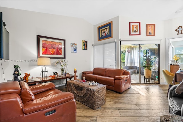 living room with light hardwood / wood-style floors and vaulted ceiling