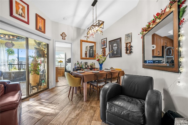 dining space featuring an inviting chandelier and vaulted ceiling