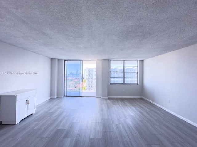 spare room featuring dark hardwood / wood-style flooring and a textured ceiling