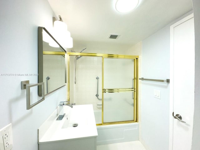 bathroom with vanity and bath / shower combo with glass door