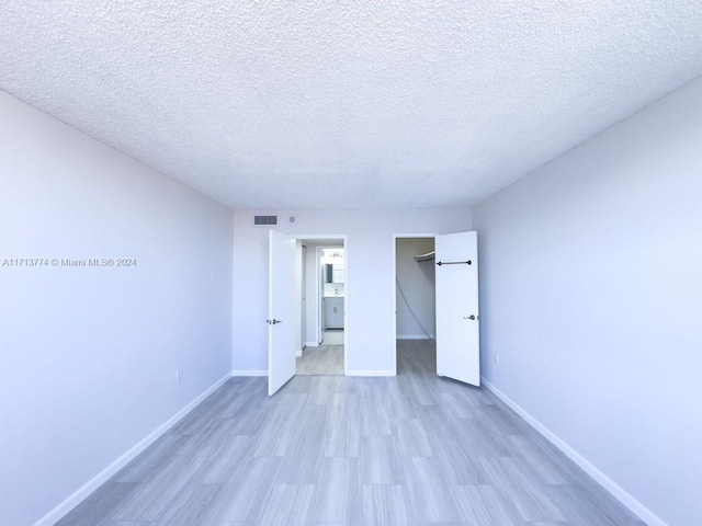 unfurnished bedroom featuring light hardwood / wood-style floors and a textured ceiling