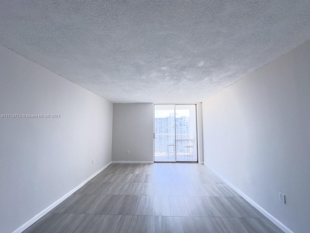 empty room with a wall of windows and a textured ceiling