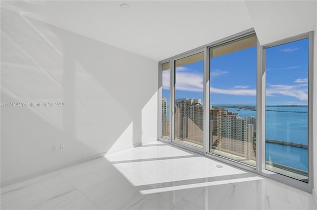 empty room with floor to ceiling windows and a water view