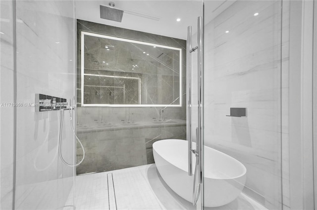 bathroom featuring shower with separate bathtub and tile walls