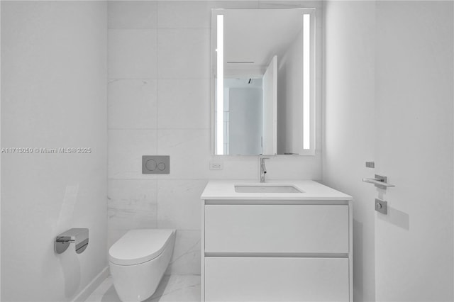 bathroom featuring vanity, tile walls, and toilet