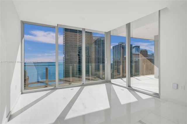 empty room featuring expansive windows and a water view