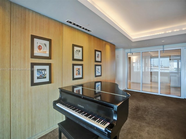 misc room featuring dark colored carpet and wooden walls