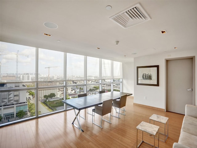 dining space featuring expansive windows and light hardwood / wood-style flooring