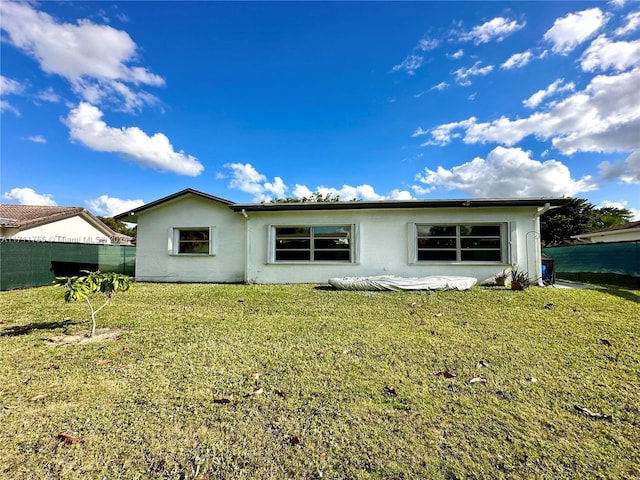 rear view of property with a lawn