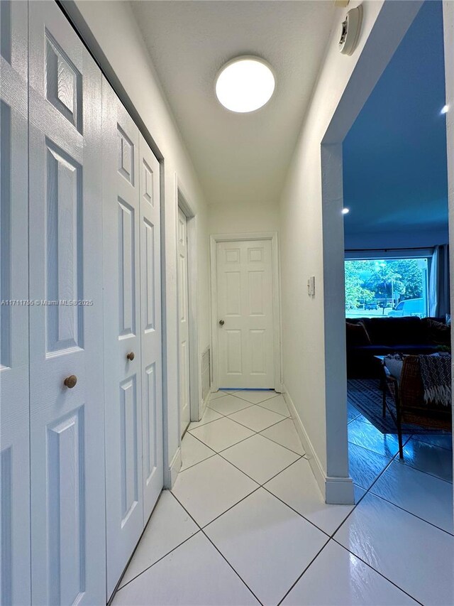 hall featuring light tile patterned floors