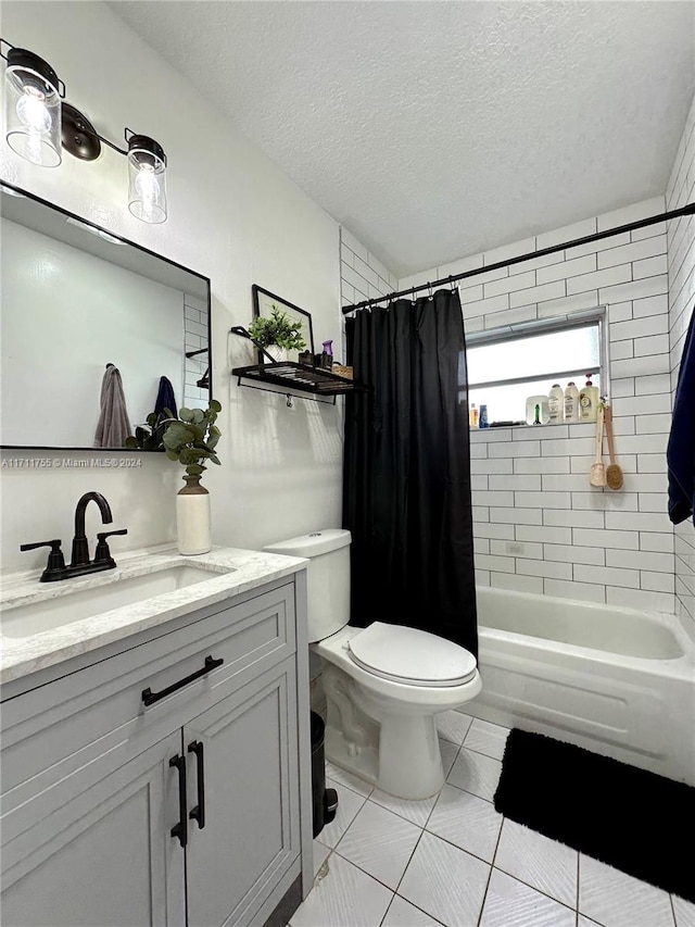 full bathroom with tile patterned floors, vanity, a textured ceiling, shower / bath combo with shower curtain, and toilet