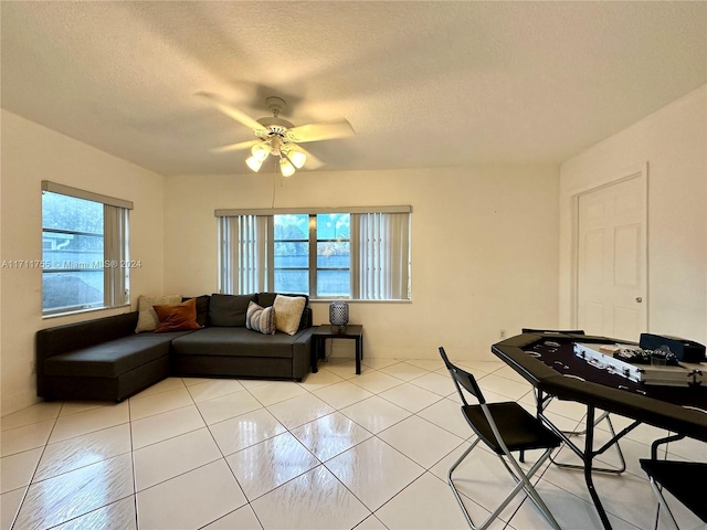 living room featuring a textured ceiling, ceiling fan, and light tile patterned flooring