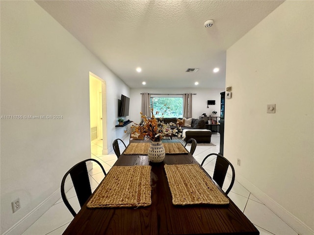 tiled dining room featuring a textured ceiling