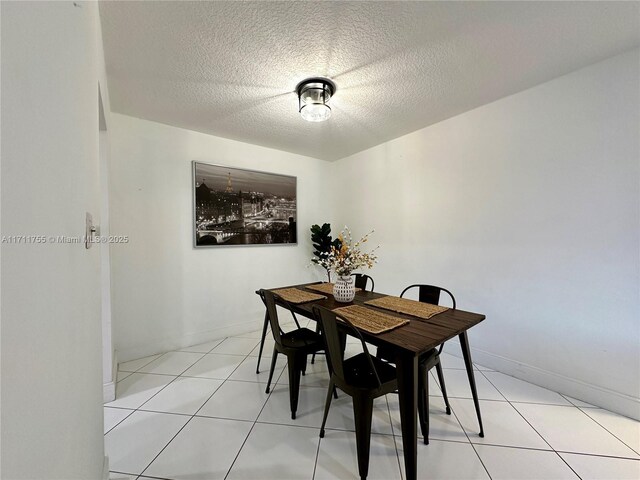 tiled dining space with a textured ceiling