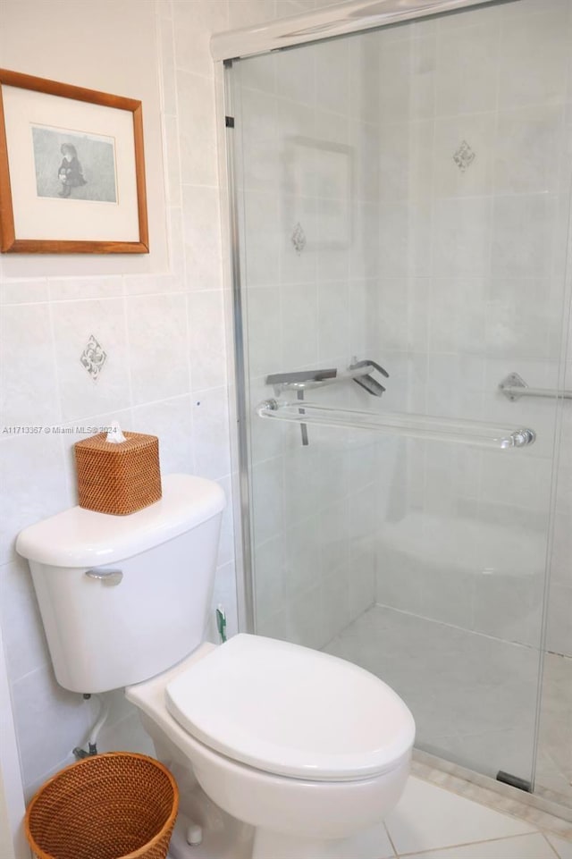 bathroom with tile patterned floors, toilet, tile walls, and walk in shower