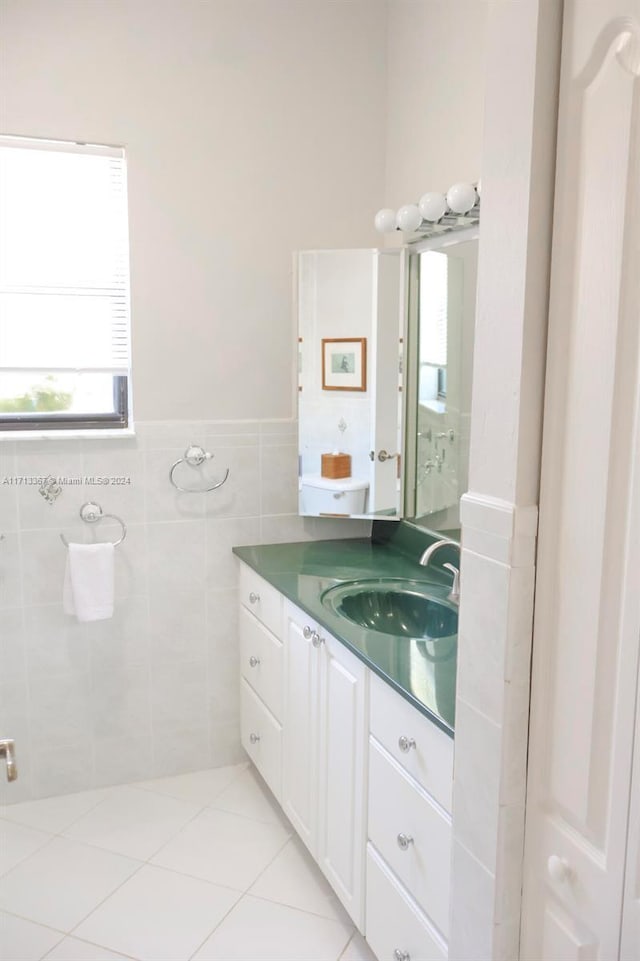 bathroom with tile patterned flooring, vanity, and tile walls