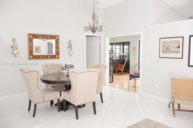 tiled dining space with high vaulted ceiling and an inviting chandelier