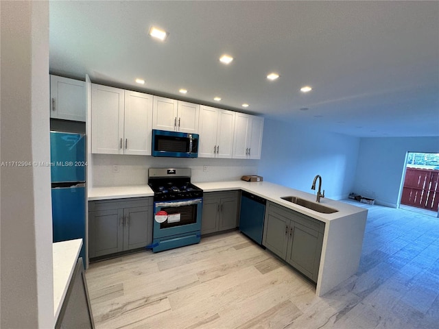 kitchen featuring dishwasher, sink, stainless steel gas range oven, refrigerator, and white cabinets