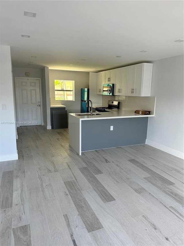 kitchen with white cabinetry, sink, light hardwood / wood-style floors, fridge, and stainless steel stove