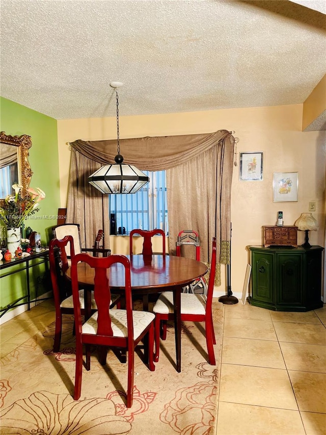 dining room with light tile patterned floors, a textured ceiling, and an inviting chandelier