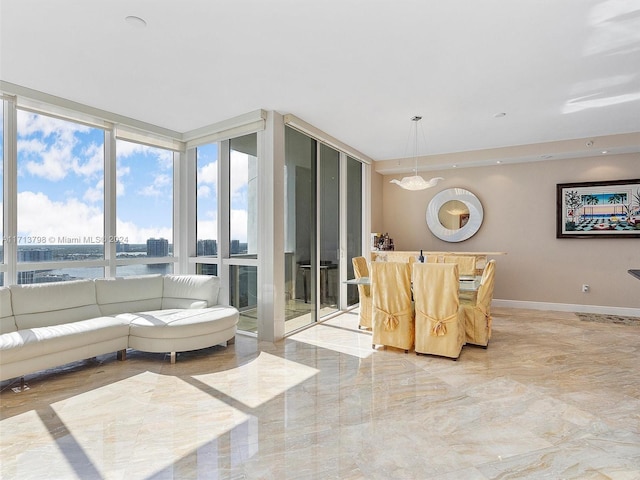 living room with a notable chandelier, floor to ceiling windows, and a water view