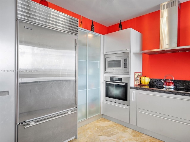 kitchen featuring built in appliances and ventilation hood