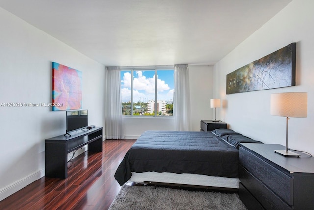 bedroom with dark hardwood / wood-style floors