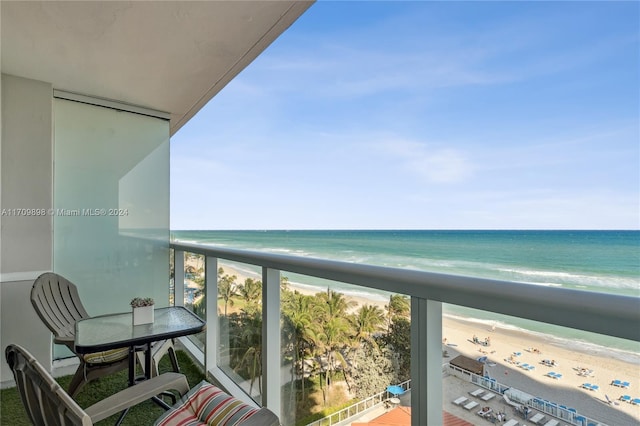 balcony featuring a water view and a beach view