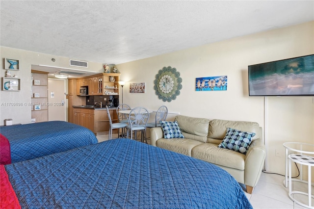 tiled bedroom featuring a textured ceiling