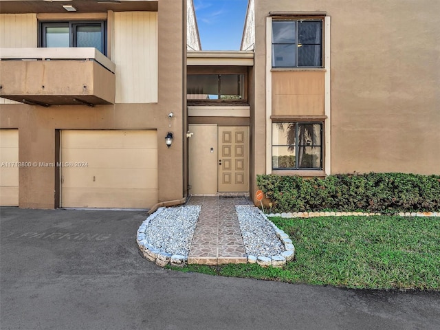 doorway to property featuring a balcony and a garage