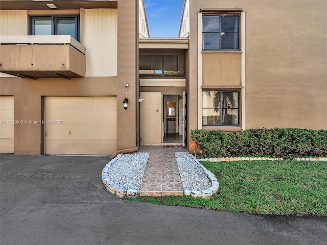 entrance to property featuring a balcony and a garage