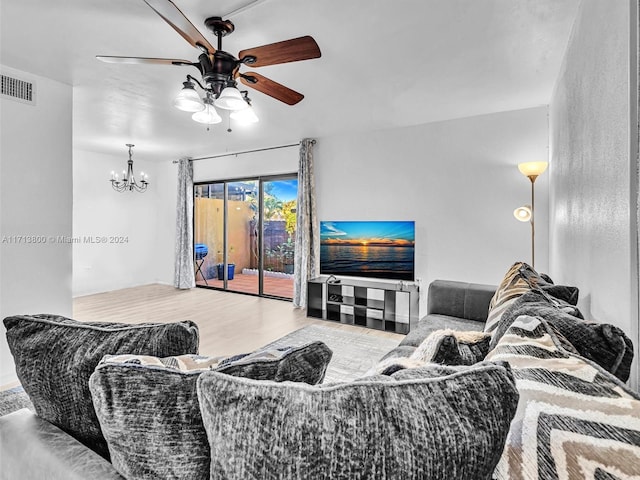 living room with wood-type flooring and ceiling fan with notable chandelier