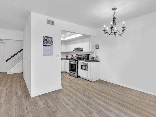 kitchen featuring stainless steel gas range oven, an inviting chandelier, white cabinets, hanging light fixtures, and light hardwood / wood-style floors