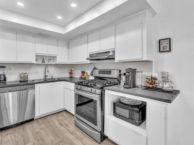 kitchen with light wood-type flooring, stainless steel appliances, white cabinetry, and sink